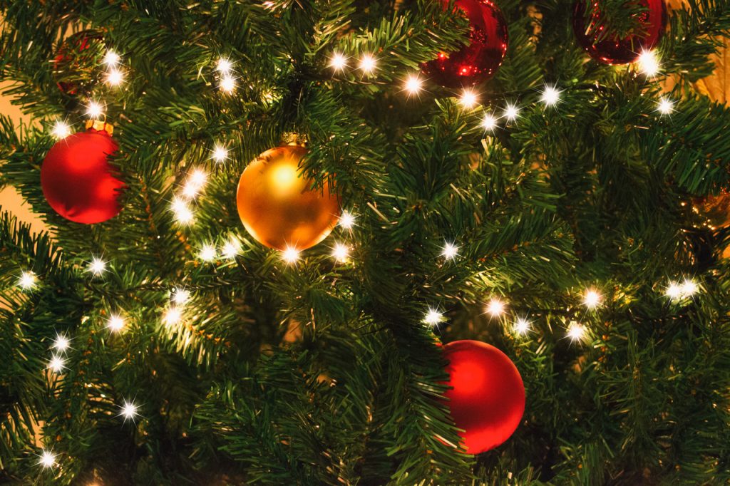 Albero di natale con lucine bianche e pallina rossa